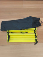 Échelle d'agilité foot repliée à côté de son sac de rangement, format compact